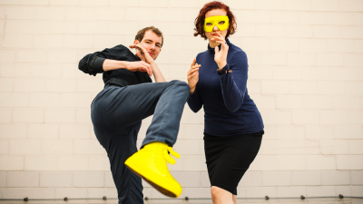 Julia Ulrich und Paul Ziehmer mit gelben Schuhen und Maske beim Bühnenkampf